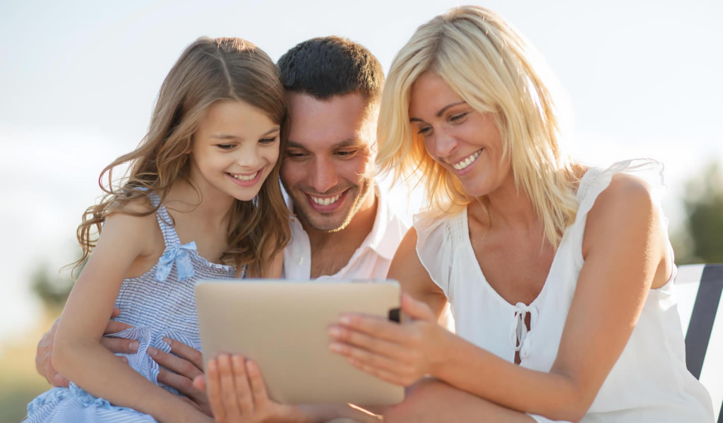 Happy family engaging with their tablet news outdoors, London City Mortgages