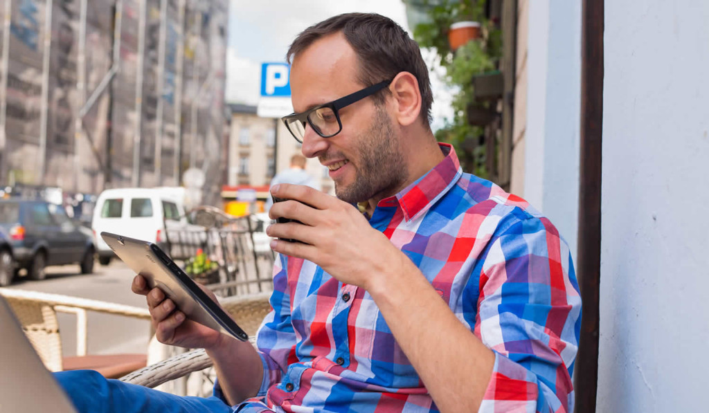 Man enjoying his coffee while receiving his tablet news, London City Mortgages