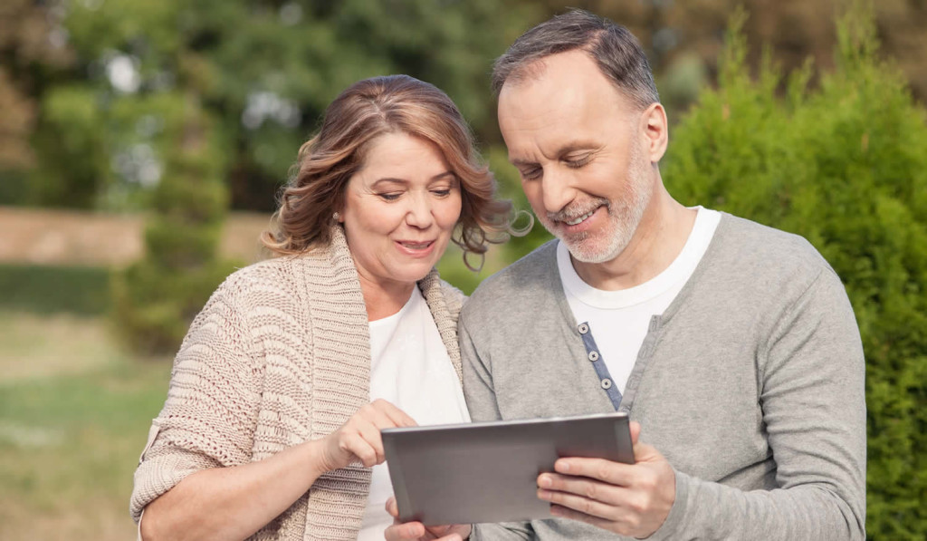 Older-couple-in-the-park-accessing-their-tablet-news-london-city-mortgages