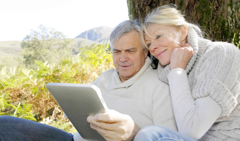 Older couple in the countryside reading their tablet updates, London City Mortgage