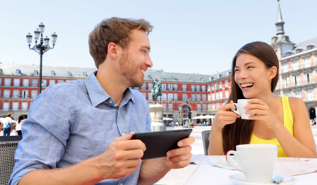 Relaxed couple in Madrid checking their tablet results, London City Mortgages