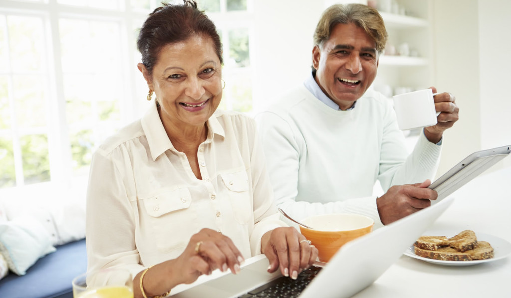 Senior couple enjoying breakfast at home reviewing their laptop and tablet news, London City Mortgages