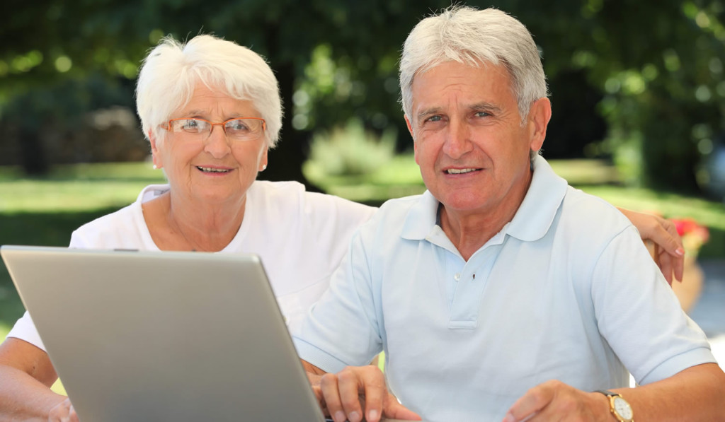 Senior couple outdoors reviewing their laptop news, London City Mortgages