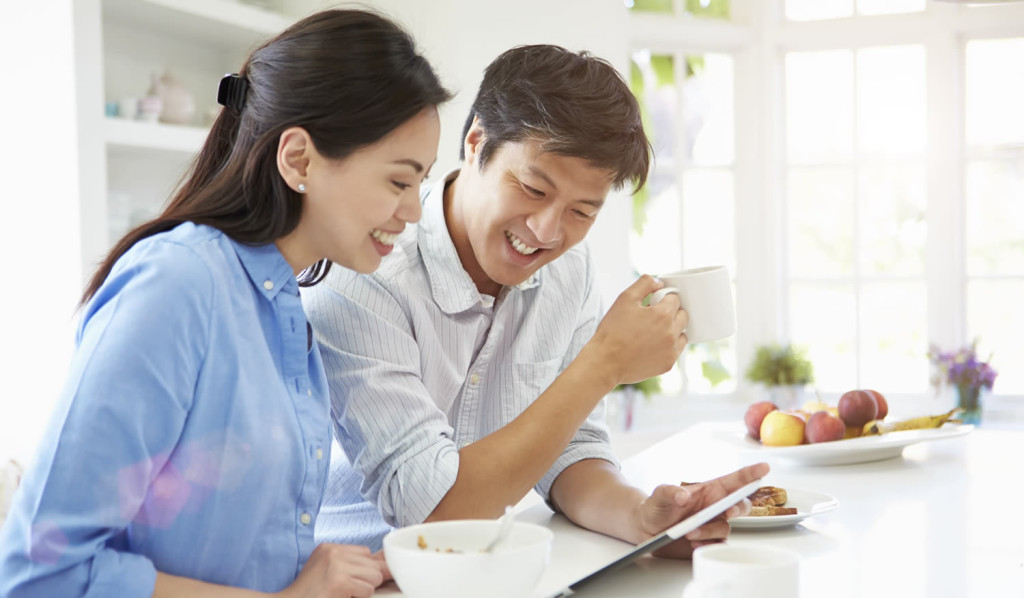 Young couple at breakfast reviewing their tablet updates, London City Mortgages