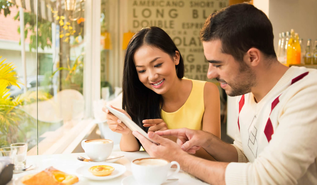 Young couple having breakfast while accessing their tablet, London City Mortgages