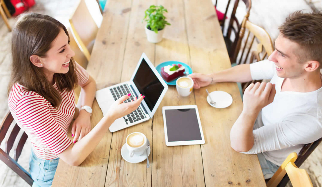 Young couple with laptop in cafe, London City Mortgages