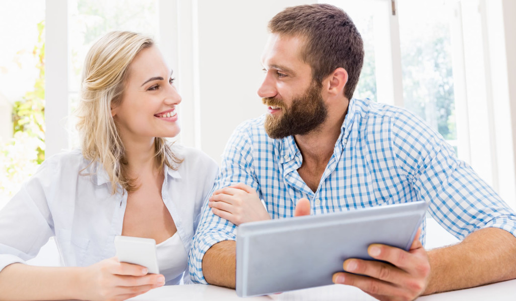 Bright dining room couple with phone tablet London City Mortgages