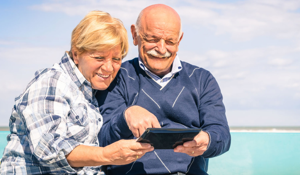 Cheerful mature couple on holiday with tablet London City Mortgages