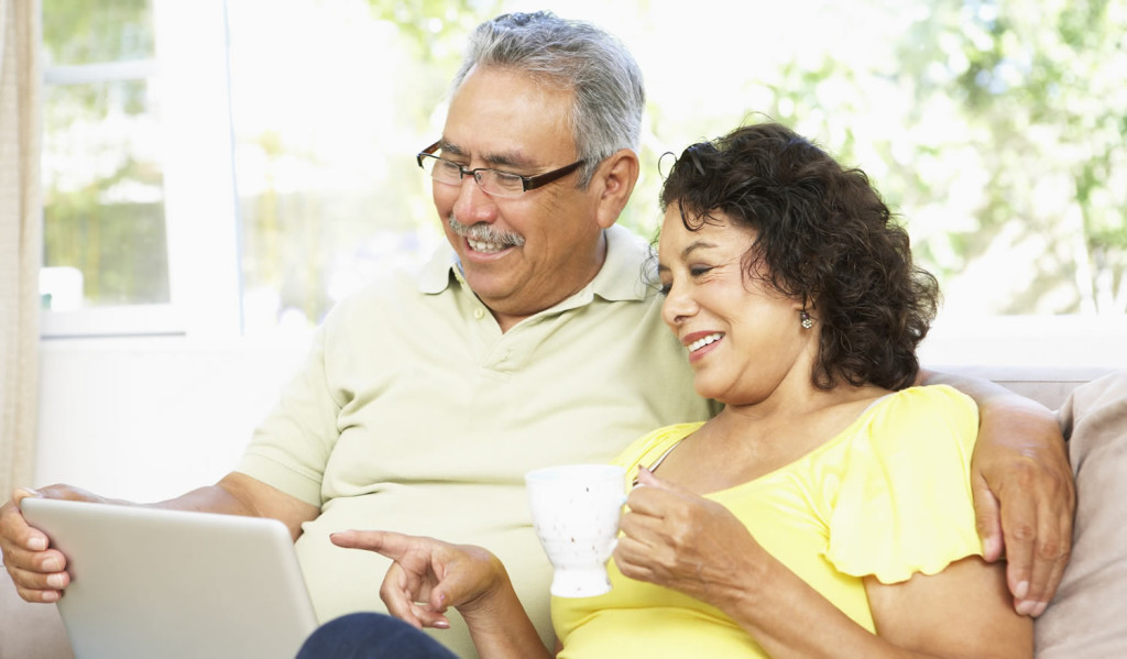 Happy mature couple on tablet London City Mortgages