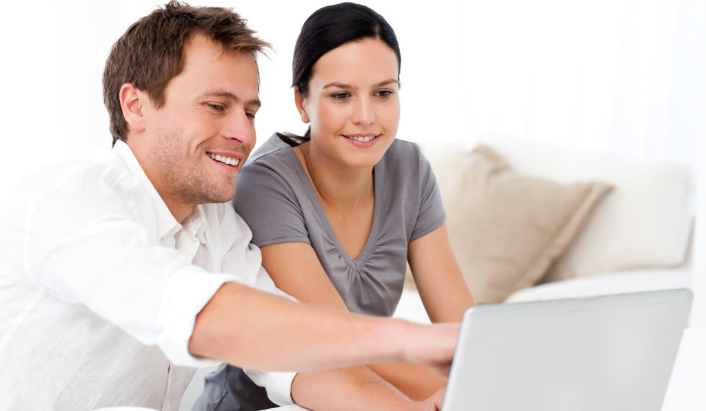 Interesting couple reviewing laptop London City Mortgages