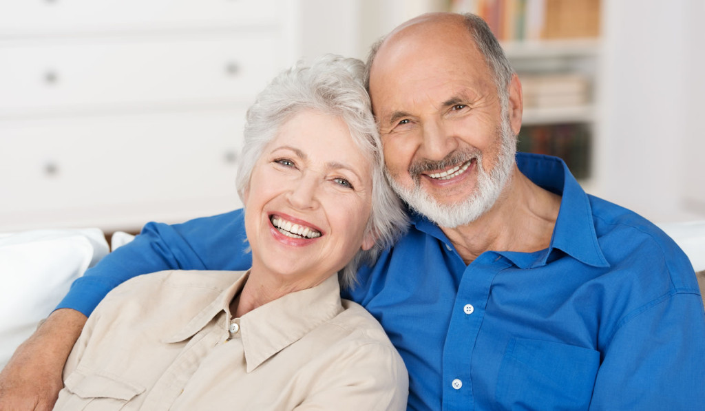 Smiling retired couple relaxing at home London City Mortgages