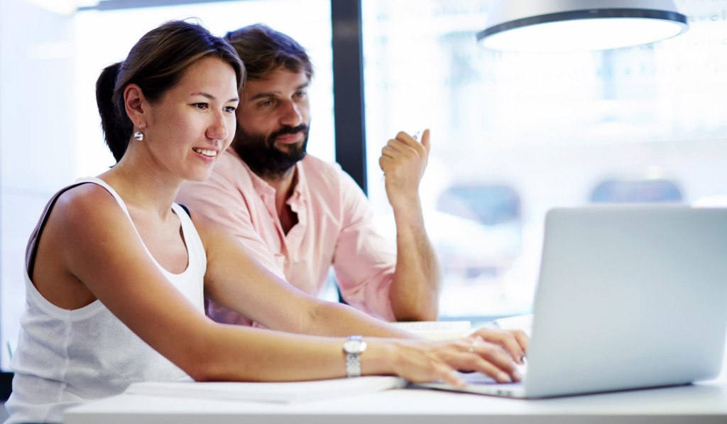 Working couple reviewing laptop updates London City Mortgages