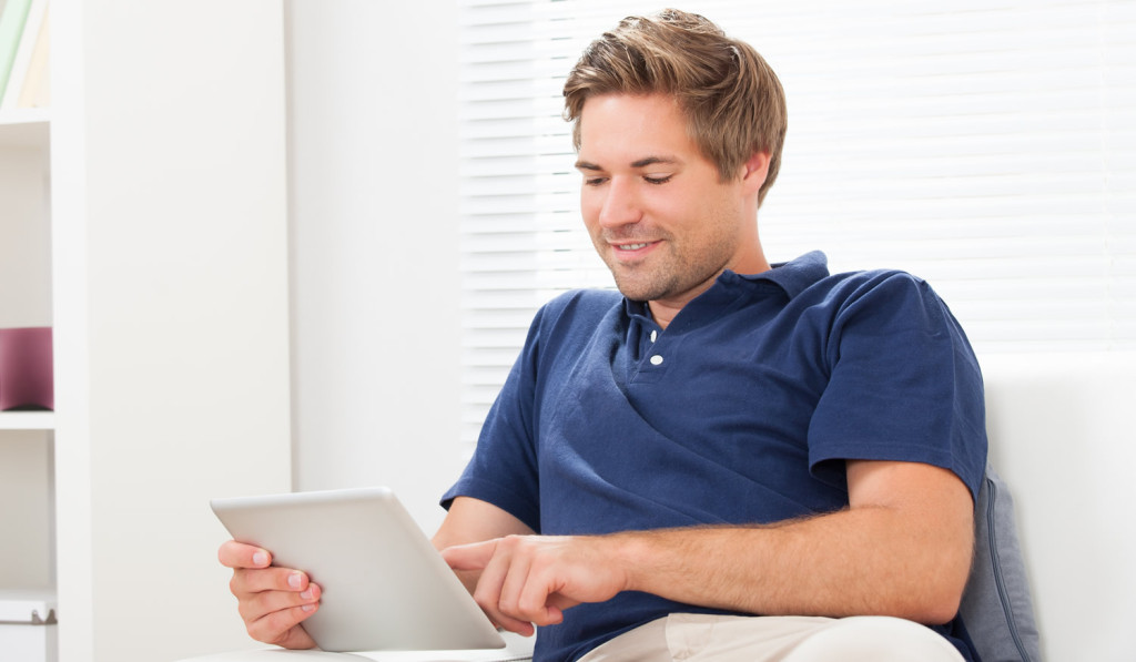 Young homeowner relaxing with tablet London City Mortgages